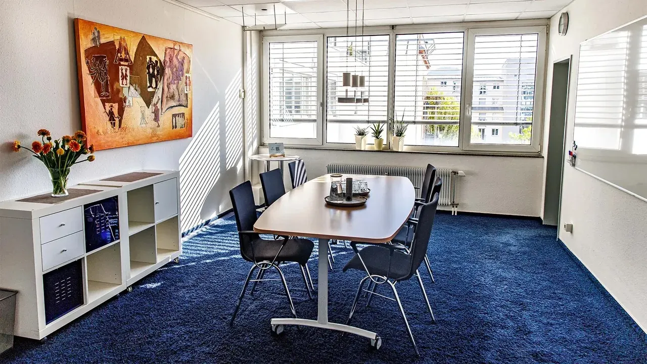 Bright office space with several workstations, view into the greenery